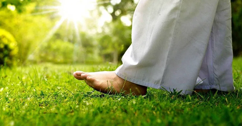 Bien-être au naturel : : image d'une personne marchant pieds nus dans l'herbe.
