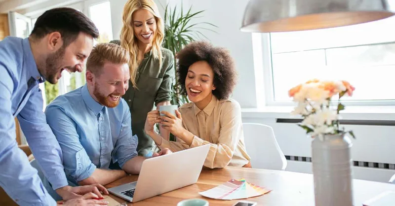Bien-être au travail : image, photo d'un groupe de personnes, hommes et femmes souriants en travaillant.